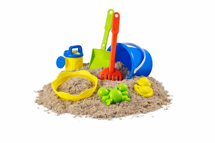 Colorful sand toys including bucket, rake, shovel, and molds on a sand pile.