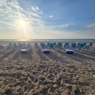 Rows of beach chairs facing the ocean at sunrise.